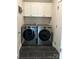 Convenient laundry room with modern appliances, overhead cabinets, and dark tile flooring at 4561 N Wynswept N Dr, Maiden, NC 28650