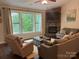 Cozy living room with a stone fireplace, comfortable seating, and large windows overlooking the backyard at 4561 N Wynswept N Dr, Maiden, NC 28650