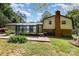 Back of house featuring sunroom, brick patio, and lush backyard with mature trees, perfect for outdoor relaxation at 503 Randa Dr, Statesville, NC 28625