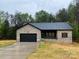 Charming brick home featuring an attached garage, covered porch, and newly seeded front yard at 5751 Selkirk Dr, Hickory, NC 28601