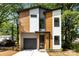 Modern two-story home featuring mixed siding, a black garage door, and professional landscaping at 620 Palmer Sw Ave, Concord, NC 28027