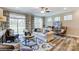 Spacious living room features hardwood floors, a ceiling fan, large windows and comfortable seating at 6266 Tea Olive Dr # 238, Harrisburg, NC 28075