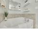 A white bathtub is set against the tiling in a brightly lit bathroom at 6842 Berewick Commons Pkwy, Charlotte, NC 28278