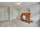 Neutral bedroom featuring a wooden rolltop desk, closet, carpet, and a light fixture at 6842 Berewick Commons Pkwy, Charlotte, NC 28278