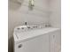 Bright laundry room with modern white appliances, wire shelving, and neutral walls at 6842 Berewick Commons Pkwy, Charlotte, NC 28278