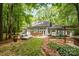 Expansive backyard features a patio with outdoor seating, sun loungers, mature trees and manicured landscaping at 6868 St Peters Ln, Matthews, NC 28105
