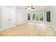 Bedroom with neutral carpet, ceiling fan, and large windows providing natural light at 6868 St Peters Ln, Matthews, NC 28105