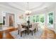 Formal dining room with hardwood floors, stylish chandelier, and access to the bathroom at 6868 St Peters Ln, Matthews, NC 28105