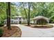 Charming traditional home with a circular driveway, lush landscaping, and mature trees at 6868 St Peters Ln, Matthews, NC 28105