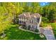 Aerial view of brick home with manicured lawn, lush landscaping, and a spacious driveway at 7896 Harbor Master Ct, Denver, NC 28037