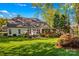 Charming backyard with a lush lawn, mature trees, a patio for outdoor dining, and a glimpse of the home's exterior at 7896 Harbor Master Ct, Denver, NC 28037