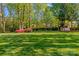 Picturesque backyard with mature trees, a lush lawn, and a charming shed, creating a serene and private outdoor space at 7896 Harbor Master Ct, Denver, NC 28037