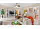 Spacious living room featuring an entertainment center, neutral decor, and an open floor plan with staircase view at 7896 Harbor Master Ct, Denver, NC 28037