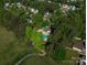 Aerial view of community pool, playground, walking trails, and wooded home lots at 7905 Sedgebrook E Dr, Stanley, NC 28164