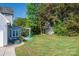 Backyard with stone patio, pergola, colorful seating, garden bed, and shed at 7905 Sedgebrook E Dr, Stanley, NC 28164