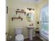 Charming half bath with pedestal sink, decorative shelves, and natural light from the window at 7905 Sedgebrook E Dr, Stanley, NC 28164