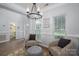 Bright entryway featuring wood floors, modern chandelier, comfortable seating, and a glimpse of the powder room at 7905 Sedgebrook E Dr, Stanley, NC 28164