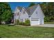 Exterior view of the home featuring a two-car garage, manicured bushes and lush green lawn at 7905 Sedgebrook E Dr, Stanley, NC 28164