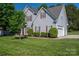 Exterior view of the home featuring a two-car garage, manicured bushes and lush green lawn at 7905 Sedgebrook E Dr, Stanley, NC 28164
