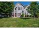 Charming two-story home with well-maintained lawn, mature trees, and classic architectural details at 7905 Sedgebrook E Dr, Stanley, NC 28164