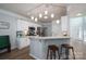Bright kitchen features white cabinets, stainless steel appliances, and marble countertops with bar seating at 7905 Sedgebrook E Dr, Stanley, NC 28164
