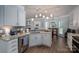 Modern kitchen featuring white cabinets, granite countertops, stainless steel appliances, and hardwood floors at 7905 Sedgebrook E Dr, Stanley, NC 28164