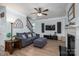 Spacious living room with fireplace, television, hardwood floors, and adjacent staircase at 7905 Sedgebrook E Dr, Stanley, NC 28164