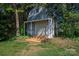 Backyard barn shed with a wood platform and surrounding greenery at 7905 Sedgebrook E Dr, Stanley, NC 28164