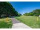 Scenic walking path with lush greenery and trees providing a serene outdoor experience at 7905 Sedgebrook E Dr, Stanley, NC 28164
