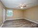This bedroom features hardwood floors, tan walls, white trim, a ceiling fan, and a double door closet at 8835 Hunter Ridge Dr, Charlotte, NC 28226