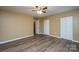 This bedroom features hardwood floors, tan walls, white trim, a ceiling fan, and double door closet at 8835 Hunter Ridge Dr, Charlotte, NC 28226