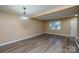 Open dining area features modern floors, fresh paint, and a window overlooking the green landscaping outside at 8835 Hunter Ridge Dr, Charlotte, NC 28226