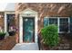 Inviting brick townhome entrance features a classic door with decorative trim and a well-maintained landscape at 8835 Hunter Ridge Dr, Charlotte, NC 28226