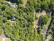 An aerial view shows a large lot with trees, a home and pool, located next to a charming neighborhood at 8903 New Town Rd, Waxhaw, NC 28173