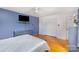 Comfortable bedroom with hardwood floors, a ceiling fan, and a mounted TV, perfect for relaxing at 910 E Center Ave, Mooresville, NC 28115