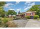 Charming brick home featuring a landscaped front yard and a cozy sunroom addition at 910 E Center Ave, Mooresville, NC 28115