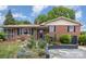 Charming brick home featuring a landscaped front yard and a cozy sunroom addition at 910 E Center Ave, Mooresville, NC 28115