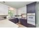 Well-lit kitchen featuring ample counter space, white cabinetry, and modern appliances at 910 E Center Ave, Mooresville, NC 28115
