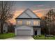 Charming two-story home with a garage and well-manicured lawn at sunset at 9423 Weston Woods Ln, Charlotte, NC 28216