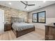 Comfortable bedroom features a rustic wood accent wall, plush bedding, and a large window for natural light at 9620 Fire Bellied Ct, Lancaster, SC 29720