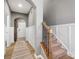 Open foyer with hardwood floors, wainscoting, and a staircase with a decorative iron railing at 9620 Fire Bellied Ct, Lancaster, SC 29720
