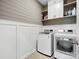 Modern laundry room with white washer and dryer, gray shiplap wall, and gray tiled floor at 9620 Fire Bellied Ct, Lancaster, SC 29720