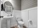 Stylish powder room features a pedestal sink, round mirror, and shiplap accent wall at 9620 Fire Bellied Ct, Lancaster, SC 29720