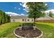 Landscaped backyard with a decorative bench, flower pots, and mature tree in meticulously maintained backyard at 9916 Meadowmead Ct # 17, Charlotte, NC 28273
