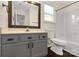 This bathroom features a vanity with sink, wood-look mirror, toilet, and shower/tub combo at 9916 Meadowmead Ct # 17, Charlotte, NC 28273