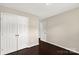 This bedroom features a closet with double doors, neutral walls, and dark wood-look flooring at 9916 Meadowmead Ct # 17, Charlotte, NC 28273