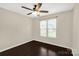 This bedroom features a ceiling fan, neutral walls, window with blinds, and dark wood-look flooring at 9916 Meadowmead Ct # 17, Charlotte, NC 28273