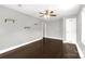 This bedroom features a ceiling fan, floating shelves, and dark wood-look flooring at 9916 Meadowmead Ct # 17, Charlotte, NC 28273