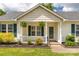 Inviting front porch features hanging ferns, a white railing, and a well-manicured flowerbed at 9916 Meadowmead Ct # 17, Charlotte, NC 28273