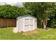 A white outbuilding sits neatly in a green backyard, offering ample outdoor storage at 9916 Meadowmead Ct # 17, Charlotte, NC 28273